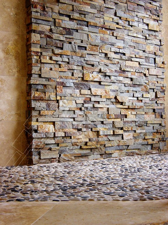 Stacked Stone on a shower wall with a pebble floor
